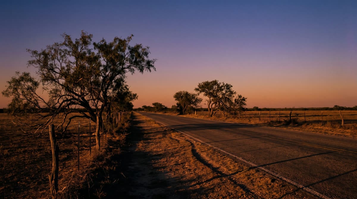 A two-lane farm road leading out of Natalia, Texas toward the interstate